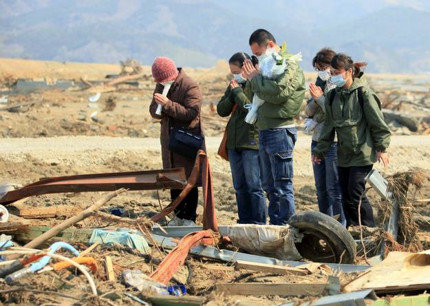 Familiares de una víctima del tsunami rezan en el lugar donde un alumno de la escuela primaria Otawa fue encontrado muerto, a unos 50 metros de la escuela, hoy, miércoles 13 de abril de 2011 en Ishinomaki, prefectura de Miyagi (Japón)