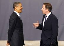 El presidente estadounidense, Barack Obama, escucha al primer ministro británico, David Cameron, durante el posado para la foto de familia de la Cumbre de la OTAN en Lisboa.
