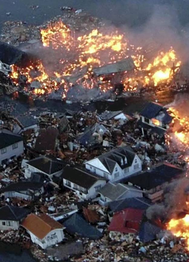 Houses swept out to sea burn following a tsunami and earthquake in Natori