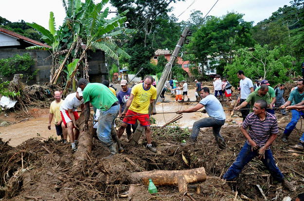 Varias personas despejan los destrozos en una zona afectada por las inundaciones en el municipio de Teresópolis, a 91 kilómetros de la ciudad de Río de Janeiro (Brasil).