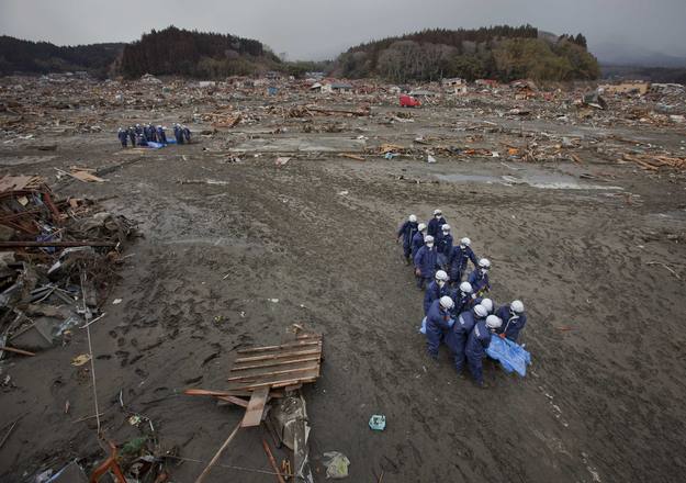 Operarios retiran el cuerpo sin vida de una de las víctimas del tsunami en Rikuzentakata