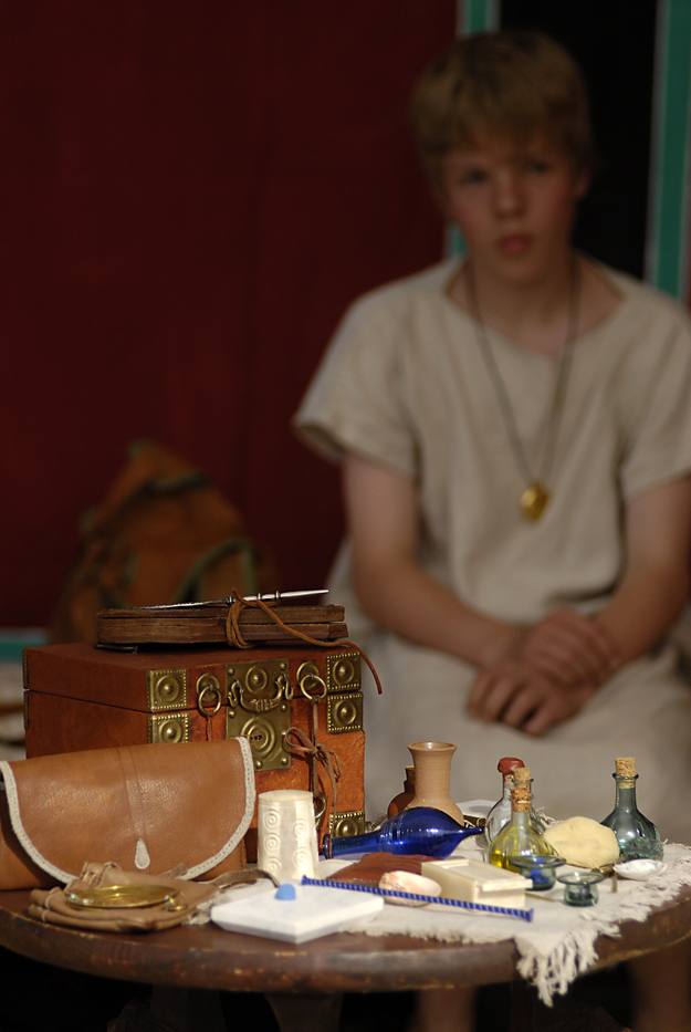Redomas con perfumes y otros objetos de lujo. El niño lleva la bulla, una bolsa, con amuletos protectores, colgada del cuello
