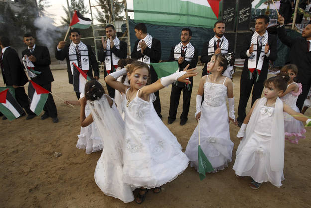 Niñas bailan ante los novios en una boda masiva en Gaza.