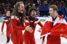 Members of the Canadian team celebrate after winning the gold medal in the men's 5000 metres relay short track final at the Vancouver 2010 Winter Olympics